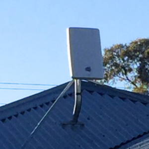 A rectangular-shaped antenna, known as an nbn Wireless Network Terminating Device Version 3, on a house roof 