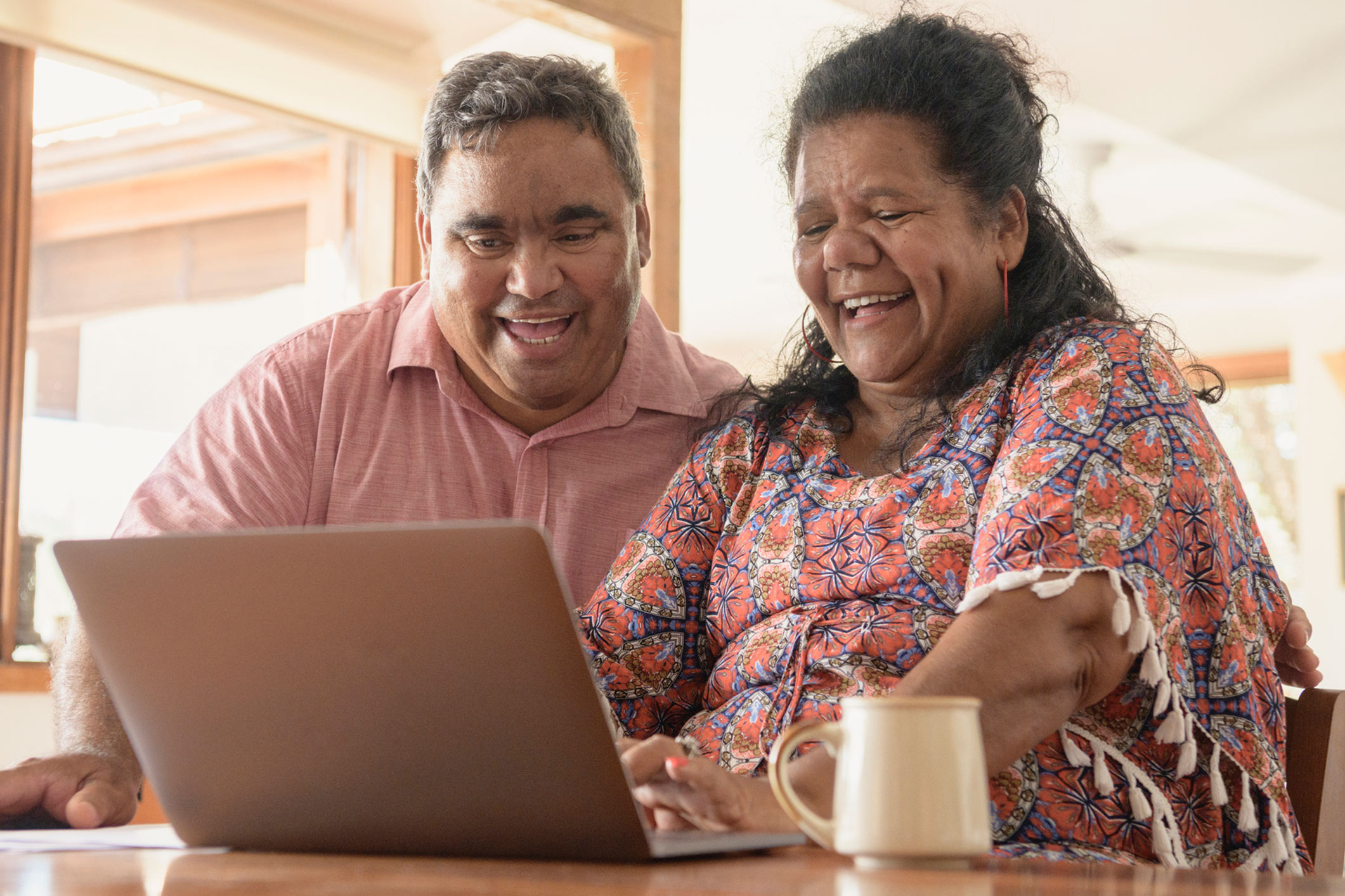 indigenous couple using a laptop
