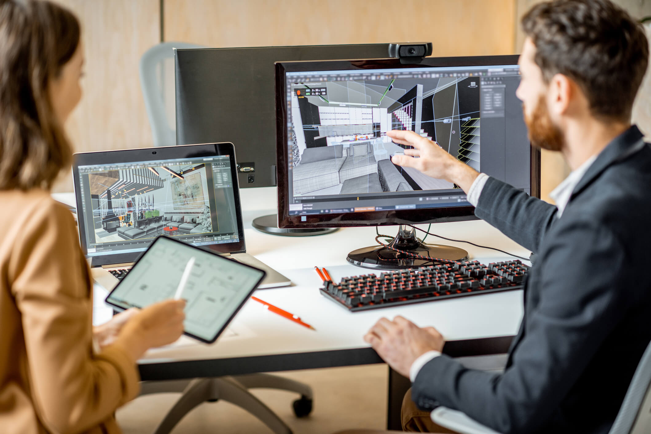 Image depicts an office setting with a man showing a woman information on a tablet.