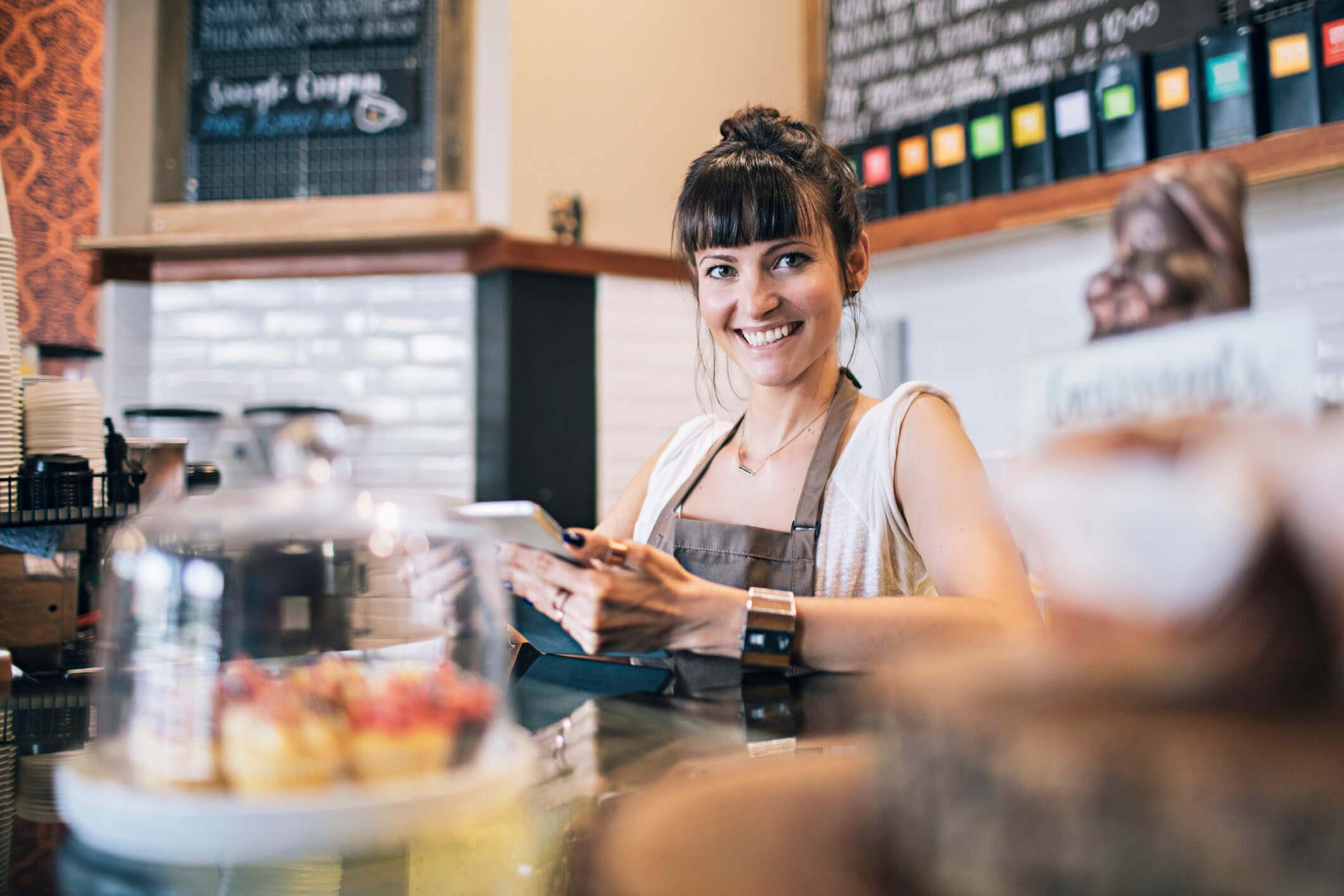 A woman uses a tablet computer in a café.