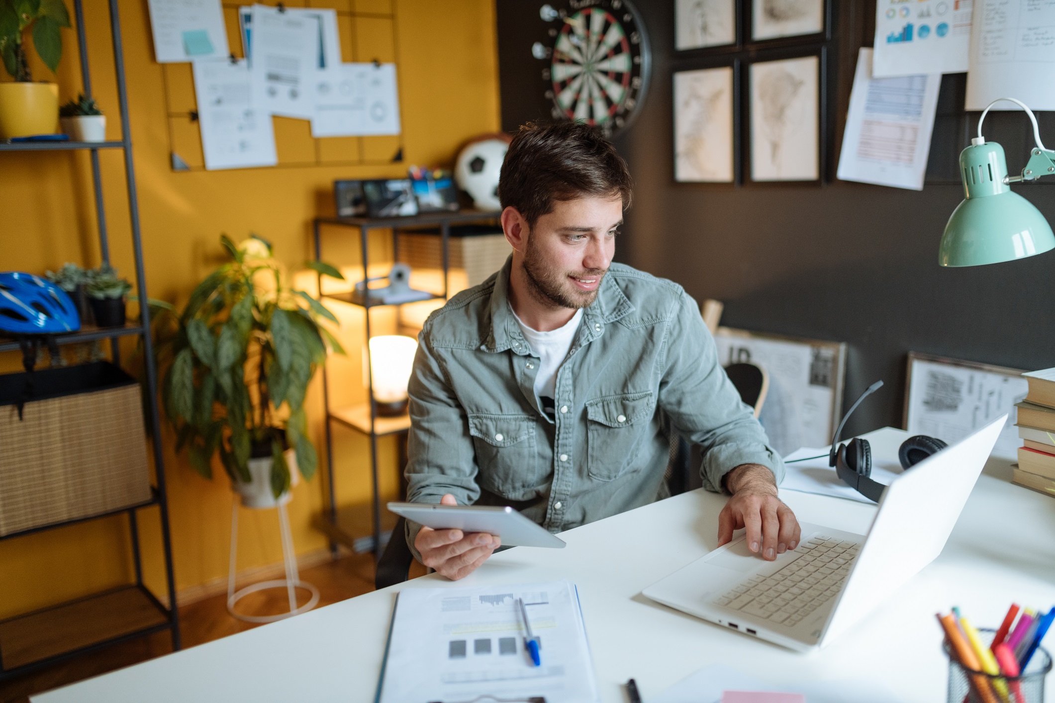 Businessman working on laptop and tablet in office