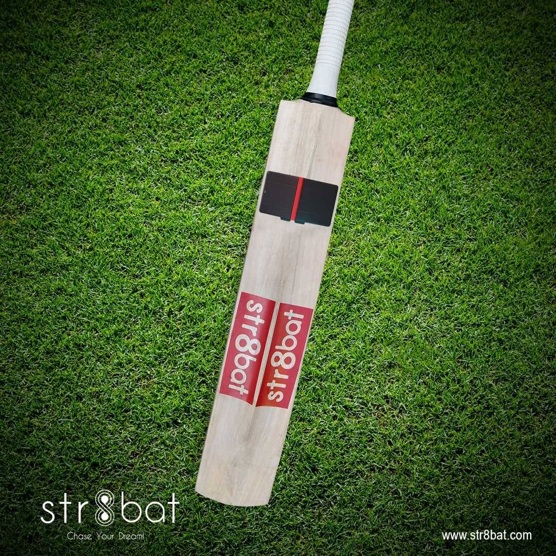 str8bat sensor on cricket bat with grass in the background