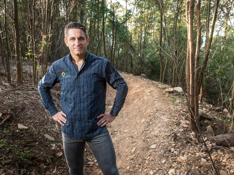 Martin Wisata, Director at The Rocky Trail Group, standing with his hands on his hips on a mountain bike trail