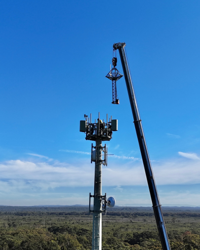 Crane lifting specially designed elevated bird's nest platform to top of nbn Fixed Wireless tower