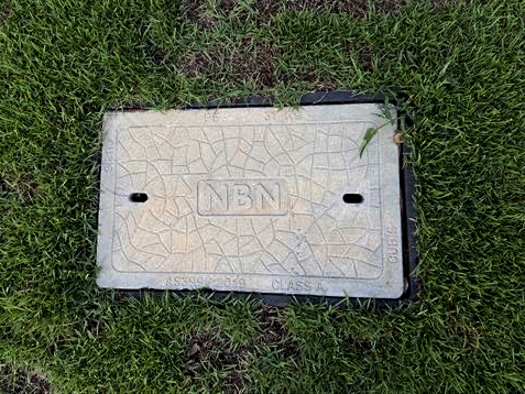 nbn underground pit lid on a footpath, providing access to underground telecommunications infrastructure.