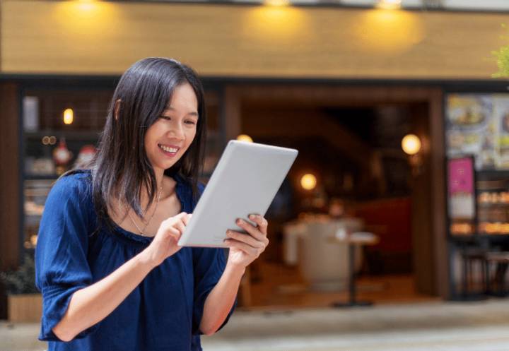 Female business owner using tablet outside shop